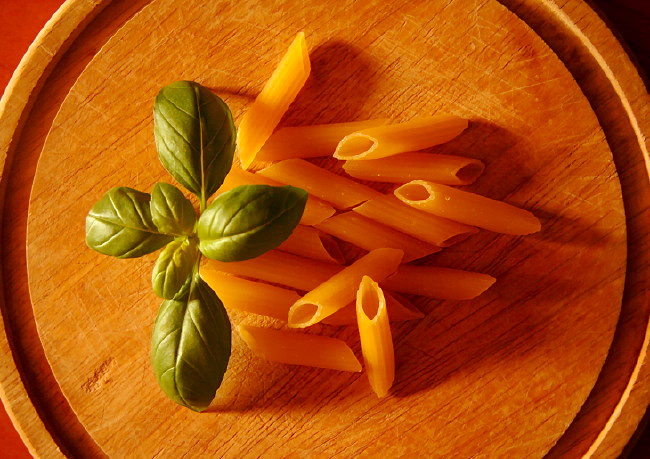 Penne und Basilikum als Grundlage für Nudelpizza